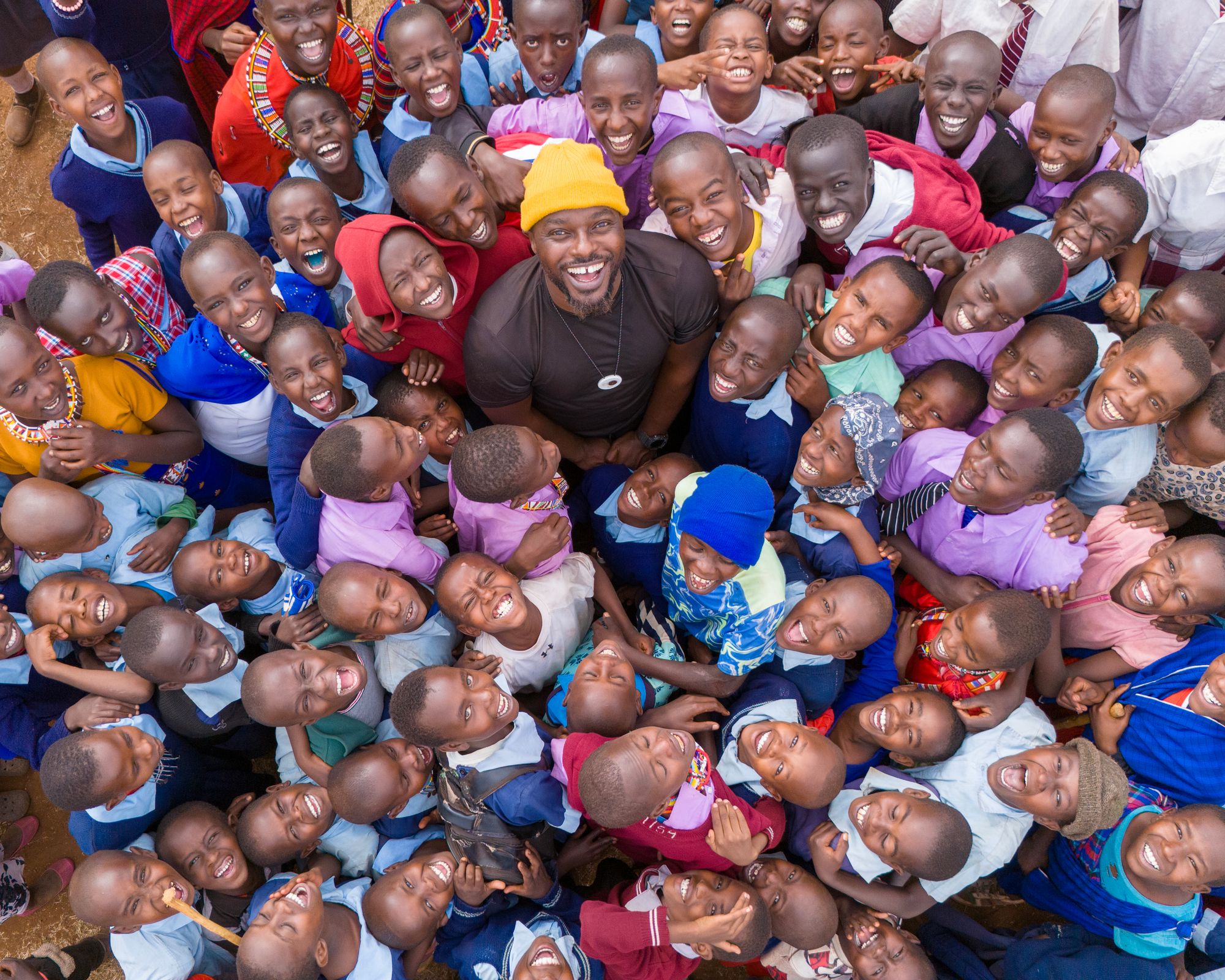 A volunteer surrounded by joyful schoolchildren at a GivePower-powered school in Kenya